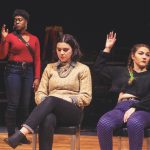 Three actors in the play Student Body. Two of them are raising their hands in a vote