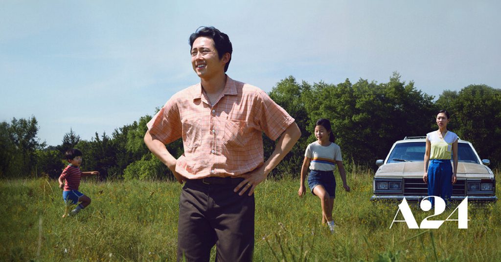 Yeun and co-stars standing in an open field