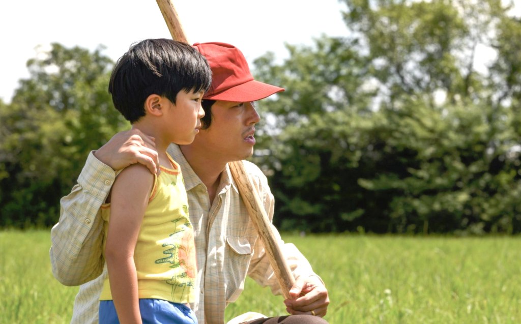 Yeun with his arm over a young boy